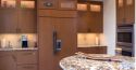 close up of a marble top island in kitchen with lots of wood cabinets