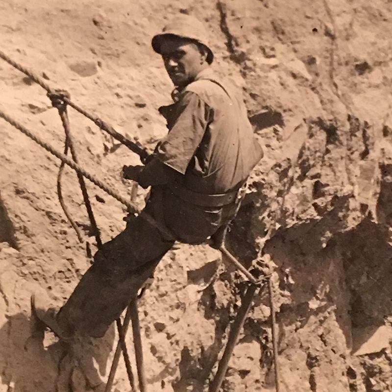 Man climbing up with a rope.